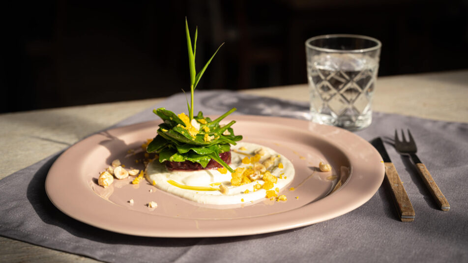 Teller mit Randen-Spinat-Eisalat in dunkler, edler Atmosphäre.