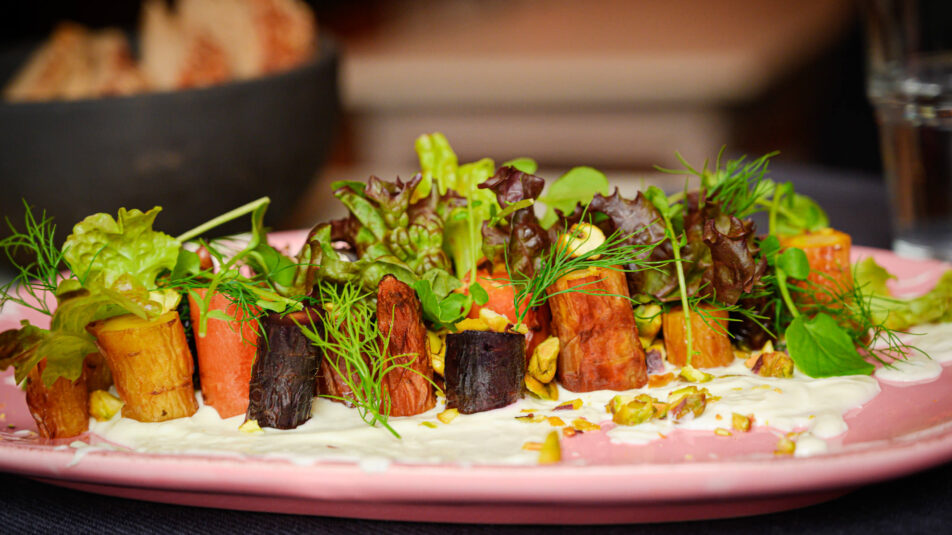 Geschmorter Karottensalat mit Joghurt, angerichtet auf einem farbenfrohen Teller.