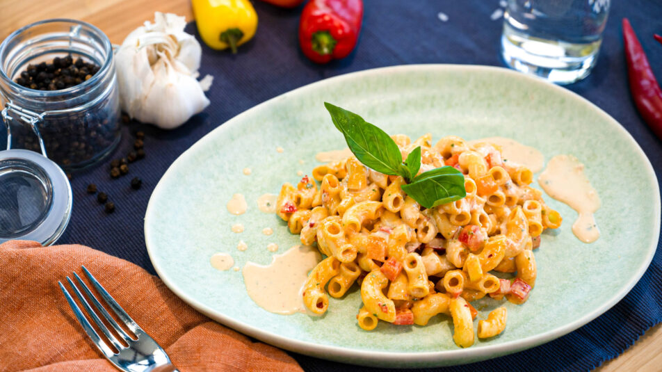 Hörnlisalat mit Basilikum und Tomaten, garniert mit frischem Basilikum.