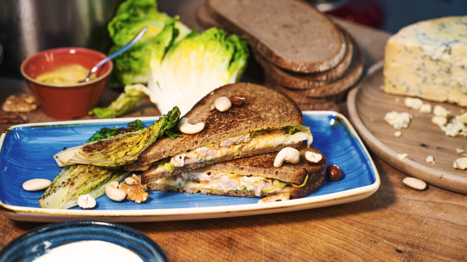 Sandwich gefüllt mit Poulet und Lattich, daneben eine Schüssel mit Brunos Salatsauce.