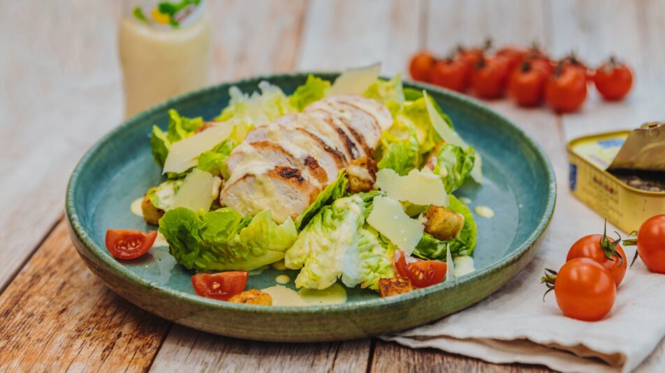 Caesar Salad mit knackigem Römersalat, knusprigen Croutons, cremige Brunos Caesar-Salatsauce, geriebenem Parmesan und saftigem gegrillten Poulet.