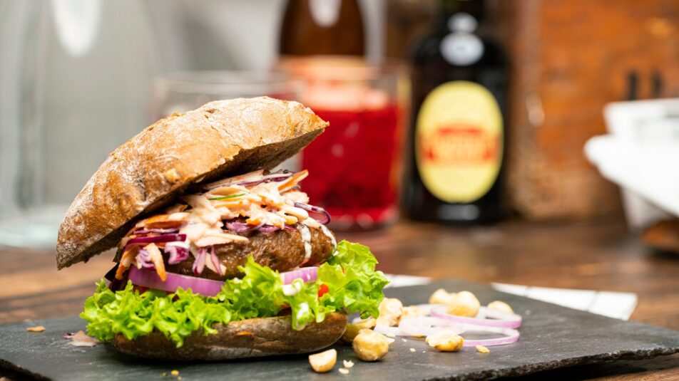 Burger mit Coleslaw-Salat auf einer Schieferplatte angerichtet.