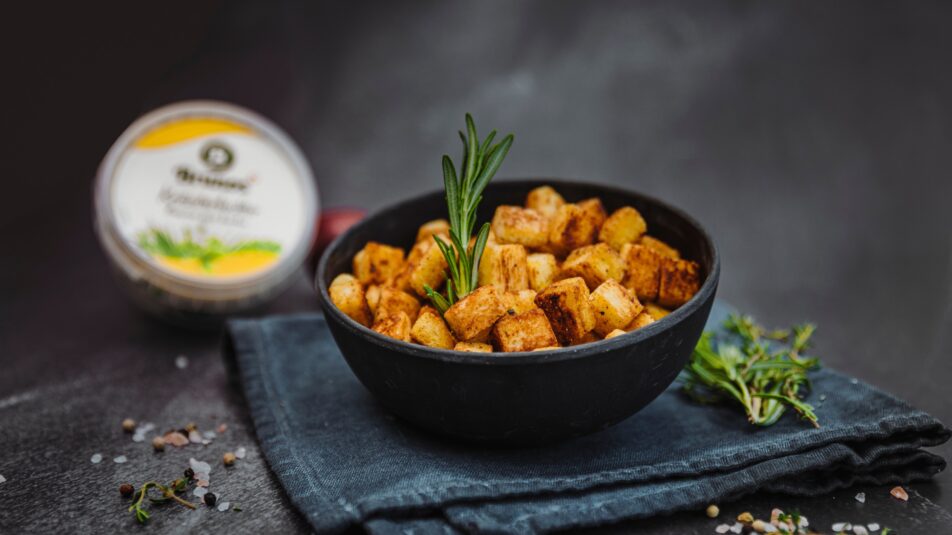 Schüssel mit frischen, selbstgemachten Croutons und einem Zweig Rosmarin.