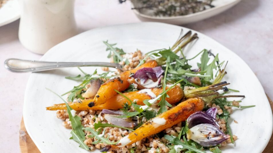 Teller mit einem Salat aus gerösteten Karotten, im Hintergrund ist eine Flasche Brunos Salatsauce zu sehen