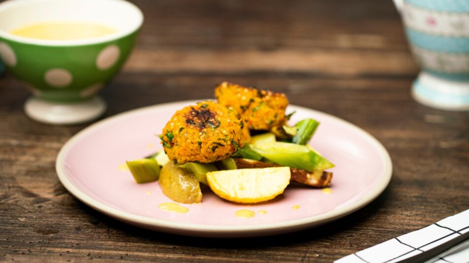 Kartoffel-Lauch-Salat mit Rüebli und Quinoa-Bällchen auf einem pinken Teller.