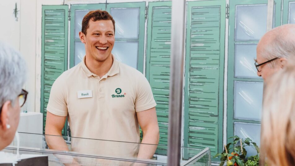 Ein Mitarbeitender der Bruno's Best AG schaut lachend in Richtung Kundschaft